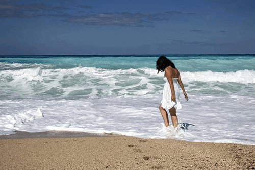 A person on a beach on their unpaid leave.