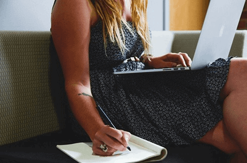 A woman writing down her employee expenses.