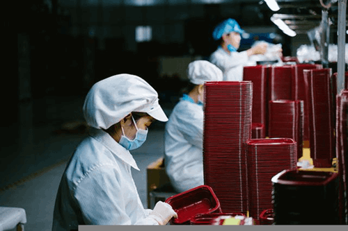 A woman packing plastic trays.