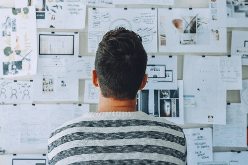 An employee examining a board full of notes