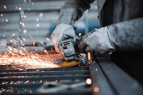 Someone using a grinder with gloves on.