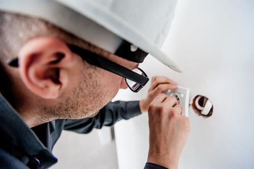 electrician fixing a plug socket