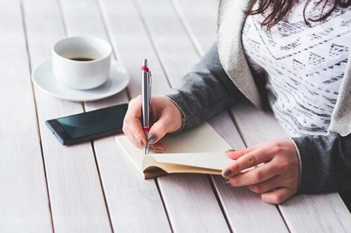 woman writing in a notepad