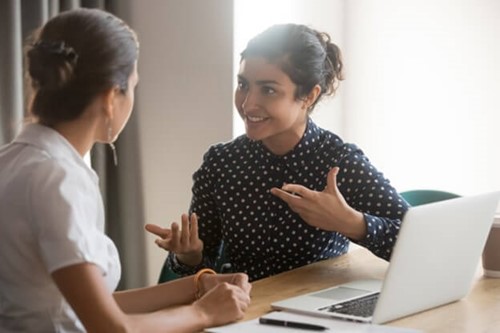 two female employees talking happily