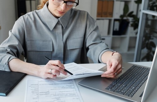 A womoan working at a desk with a laptop.