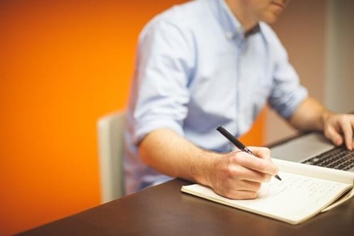 an employer making notes at their desk