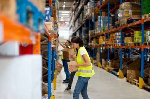 two warehouse workers stacking shelves.