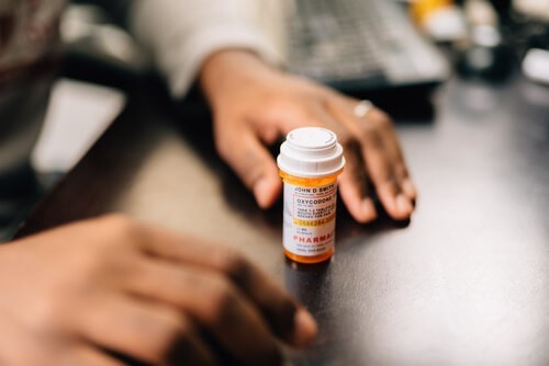 An employee opening a bottle of pills needed for their health problem