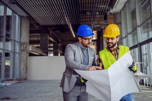 Two employees discussing rules on managing health and safety policy statement.