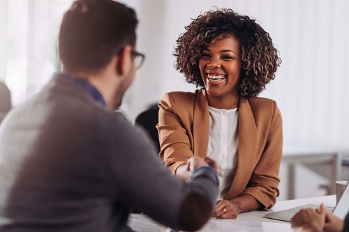 An employer smiling after hiring a new employee