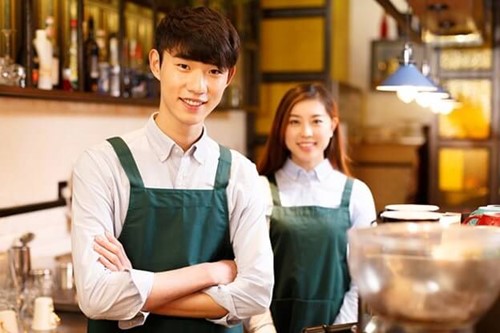 Two people working in a cafe with uniform