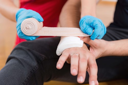 A trained person taping up an injured hand